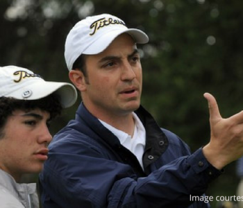 Coach helping high school golfer